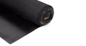 Rotolo di materiale nero con superficie rigata per applicazioni industriali